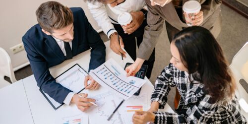 Photo by Yan Krukau A diverse team in business attire collaborates over graphs and charts for a successful project.