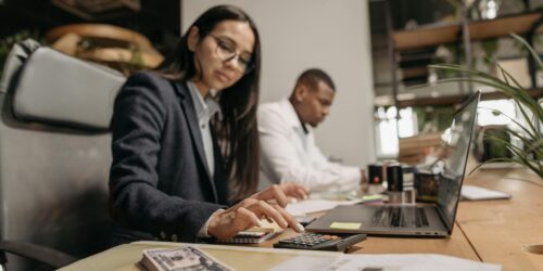 Photo by Pavel Danilyuk Two business professionals collaborating with a laptop and calculator in a modern office.